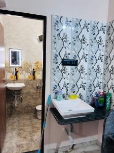 een badkamer met een wastafel, een toilet en een spiegel bij 1BHK Holiday Home in Nagpur