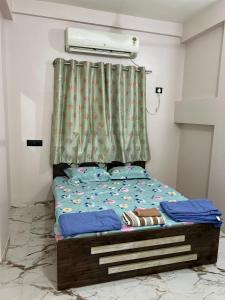 a bedroom with a bed with a green curtain at 1BHK Holiday Home in Nagpur