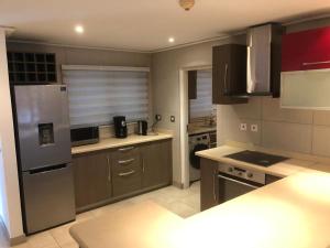 a kitchen with a stainless steel refrigerator and cabinets at Beaufort Ridge Apartments Accra in Accra