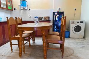 a kitchen with a table and chairs and a refrigerator at Panaiyur Guest house in Chennai