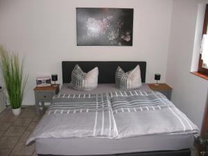 een slaapkamer met een groot bed met gestreepte kussens bij Ferienwohnung Pargen in Bullay