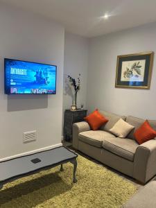 a living room with a couch and a flat screen tv at Spencer bridge by AFL in Northampton