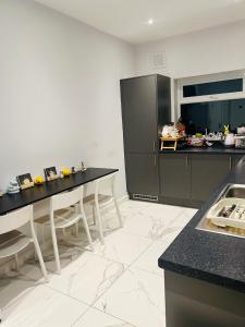 a kitchen with black and white counters and tables at Spencer bridge by AFL in Northampton