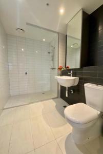 uma casa de banho com um WC, um lavatório e um chuveiro em Cozy 2BR Apt Next to Southern Cross FREE Parking em Melbourne