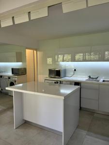 a kitchen with white cabinets and a white counter top at Saloniky Garden in H̱olon