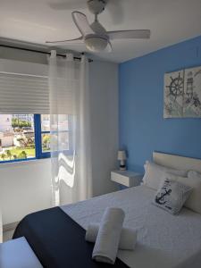 a blue bedroom with a bed and a ceiling fan at Apartamento enfrente la playa in Alcossebre