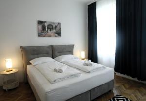 um quarto com uma cama com duas almofadas brancas em Casa Nostra - Schöne 3-Zimmerwohnung am Augarten em Viena