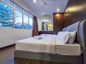 um quarto com uma cama grande com lençóis brancos e almofadas em KL Secret Karaoke Private Pool Villa em Ampang