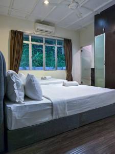 a bedroom with a large white bed with a window at KL Secret Karaoke Private Pool Villa in Ampang