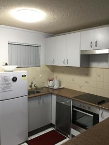 a kitchen with white cabinets and a white refrigerator at Oceanside Hawks Nest in Hawks Nest