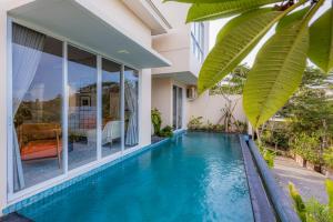 a swimming pool in front of a house at Alveshouse Suite Bali Villa - Nusa Dua in Ungasan