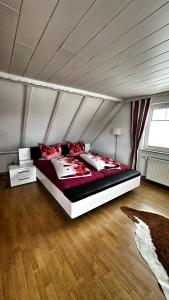a bedroom with a large bed with red pillows at Ferienwohnung Hanna in Longkamp