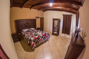 sypialnia z łóżkiem i lustrem w obiekcie Casa Luna w mieście Quetzaltenango