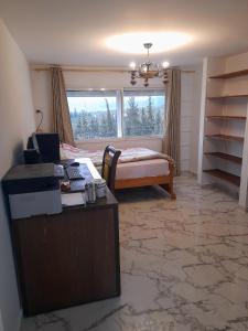 1 dormitorio con cama, escritorio y ventana en Maison de campagne à 20mn du centre ville Tunis en Mornag