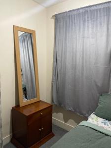 1 dormitorio con espejo, 1 cama y vestidor en Stay with Light en Ipswich
