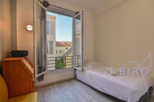 ein Schlafzimmer mit einem Bett und einem großen Fenster in der Unterkunft Bright apartment in the Heart of Nice in Nizza