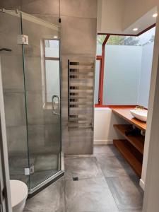 a bathroom with a glass shower with a toilet at Countryside Gem - Waimate North in Waimate North