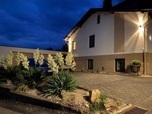 a white building with plants in front of it at Ferienwohnung Hanna in Longkamp