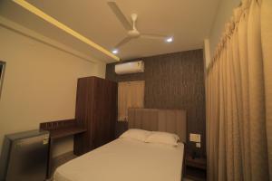 1 dormitorio con 1 cama y ventilador de techo en K LUXURY INN, en Chennai