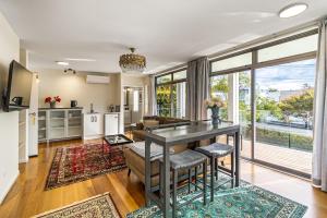 a kitchen and living room with a table and chairs at The Bays Bed & Breakfast in Auckland