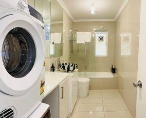een witte badkamer met een wasmachine bij D101 Charming Apartment- Free Parking in Melbourne +13 foto's