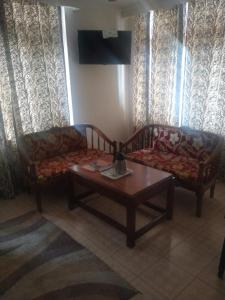a living room with two couches and a coffee table at Ravine hights in Dharamshala
