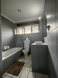 y baño con bañera, aseo y bañera. en Mitchell Guesthouse, en Pietermaritzburg