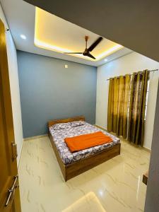 a bedroom with a bed with an orange blanket on it at The Saltwater Home stay in Udupi