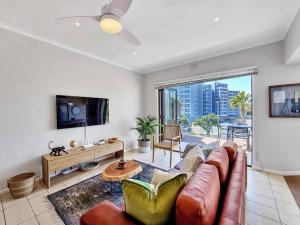 a living room with a couch and a tv at Sea La Vie + Inverter+Parking in Cape Town