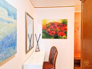 une peinture de fleurs rouges sur un mur à côté d'un bureau dans l'établissement San Lorenzo Apartment, à Portorož