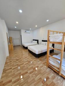 Pokój z 3 łóżkami piętrowymi i drewnianą podłogą w obiekcie Vamin Poolvilla Chiangkhan Loei วามินทร์พูลวิลล่า เชียงคาน เลย - วามินทร์ รีสอร์ท w mieście Chiang Khan