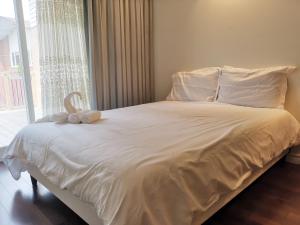uma cama com um bicho de peluche sentado em cima dela em Private Rooms in House in North York Shared Kitchen em Toronto