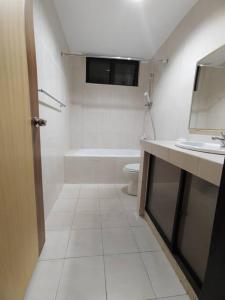 een witte badkamer met een toilet en een wastafel bij Home away from home in Miri