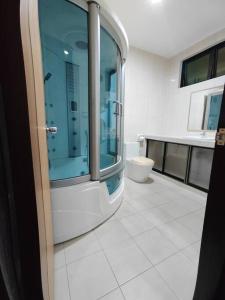 een badkamer met een glazen douche en een toilet bij Home away from home in Miri