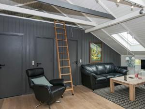 - un salon avec une échelle et un canapé en cuir dans l'établissement 6 person holiday home in Oksb l, à Oksbøl
