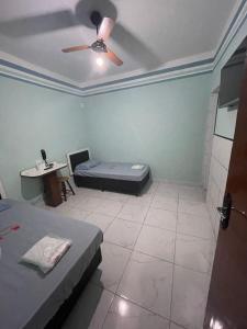 a room with two beds and a ceiling fan at Hotel Karisma II in São Bernardo do Campo