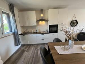 a kitchen with white cabinets and a table with chairs at Holiday Home Kristin in Mirce