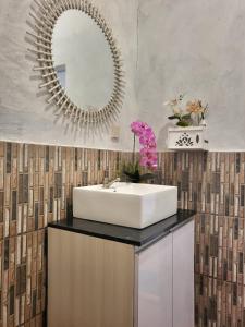 uma casa de banho com um lavatório e um espelho em Bruri Villa em Alor-kecil