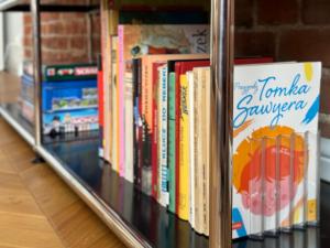 uma fila de livros numa prateleira numa loja em Tom Sawyer’s 3 room Old Town Apartment em Breslávia