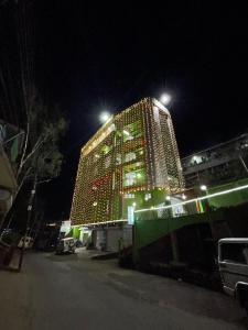 a large building with lights on it at night at 2K HOTEL in Kohīma