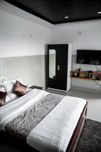 a bedroom with a large bed and a tv at 2K HOTEL in Kohīma