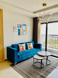 - un salon avec un canapé bleu et une table dans l'établissement Homestay Hạ Long, à Hạ Long