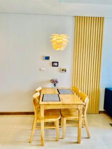 - une salle à manger avec une table et des chaises en bois dans l'établissement Homestay Hạ Long, à Hạ Long