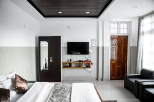 um quarto com uma cama, um sofá e uma televisão em 2K HOTEL em Kohīma