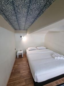 twee bedden in een kamer met een schuin plafond bij 7ATHENS in Athene