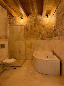 a bathroom with a bath tub and a toilet at Göreme Escape Cave Suites in Goreme