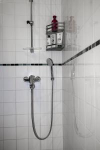 a bathroom with a shower with a shower head at Design stay in the heart of Punavuori in Helsinki