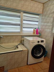 - un lave-linge dans la cuisine avec une fenêtre dans l'établissement Aido ir Jovitos sodyba Jorunas, à Kernavė