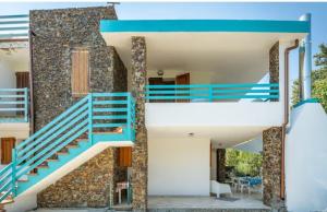 una casa con escaleras azules y una pared de piedra en Villa Gio' Iun R4245, en Sinnai