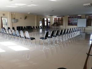 ศูนย์สัมมนาอาร์มทอง في Ban Khlong Kathon: صف من الكراسي في غرفة ذات أرضية بيضاء